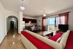 a living room with a large couch and a kitchen at Hotel Joni Lukove in Lukovë