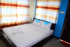 ein Schlafzimmer mit einem weißen Bett mit einer Schleife darauf in der Unterkunft Hotel Asad in Mymensingh
