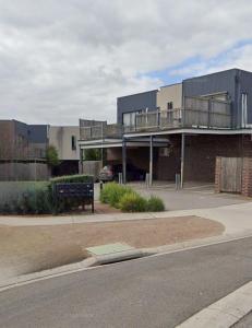 a building with a balcony on the side of a street at Ground level unit with private courtyard in Melton
