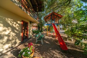 a playground with a red slide next to a building at Pousada Drehmer Haus in Gramado