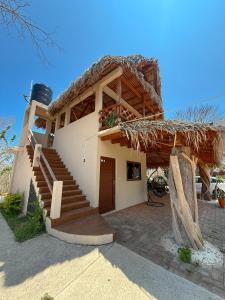 a house with a thatched roof with a staircase at Cabañas Raíces del Cielo in Estorpio +15 photos