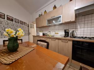 a kitchen with a table with a vase of flowers on it at Villa Boema- with parking for large business groups in Bucharest
