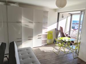 a living room with a table and a chair at Beach 50 m , vue mer in Carnon-Plage