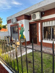 a building with a fence in front of it at Casa Hotel Cactus 15 minutos desde Ezeiza. in Monte Grande