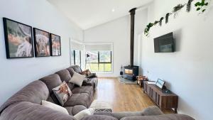 ein Wohnzimmer mit Sofa und Fernseher in der Unterkunft Bronte Snug in Bronte
