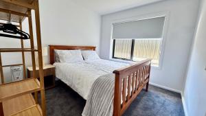 ein Schlafzimmer mit einem Bett und einem großen Fenster in der Unterkunft Bronte Snug in Bronte