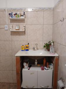 a bathroom with a sink and a shelf under it at Quarto Privativo e Camping em Canoa Quebrada in Canoa Quebrada +14 photos