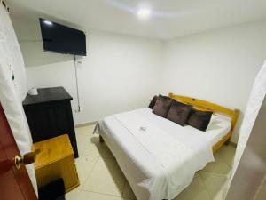 a bedroom with a bed and a flat screen tv at Hotel Colonial Betulia D in Tunja