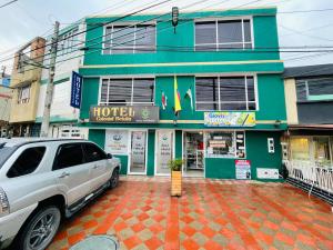 a white car parked in front of a building at Hotel Colonial Betulia D in Tunja