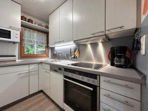 a kitchen with white cabinets and a stove top oven at Haus Anna in Stadlern