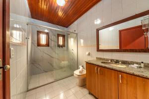 a bathroom with a shower and a toilet and a sink at Pousada Drehmer Haus in Gramado