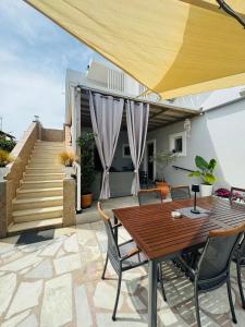 a patio with a wooden table and chairs at Yanna's Apartments in Sidari