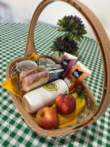 a basket of food on a table with apples and bananas at Mini Fazenda Park in Santana do Livramento