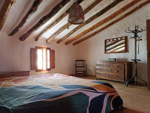a bedroom with a large bed and a dresser at El Bosquet 1897 in Mogente