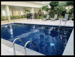 a large swimming pool with chairs in a building at Inn on The Park in Honolulu