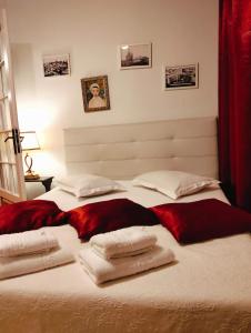 a bedroom with a large bed with towels on it at Villa Boema- with parking for large business groups in Bucharest