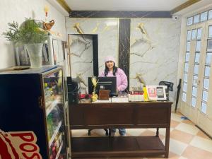 a woman standing at a desk in a room at Hotel Colonial El Bosque A in Tunja