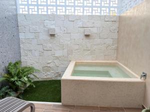 a hot tub in a building with a stone wall at Suite Deluxe con piscina privada en Valladolid - Penca Leonor 11 in Valladolid +2 photos