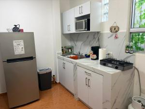 eine Küche mit weißen Schränken und einem Kühlschrank in der Unterkunft Depa B Bosques del Contry in Monterrey