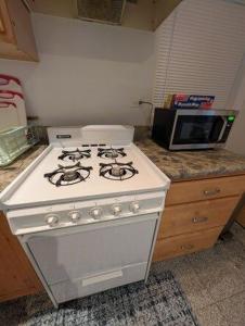 a white stove in a kitchen with a microwave at Comfortable living, within reach! in Oak Park