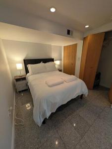 a bedroom with a large bed with white sheets at Comfortable living, within reach! in Oak Park