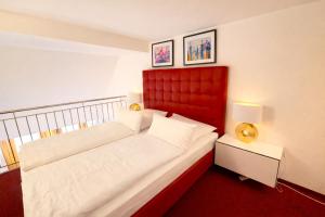 a bed with a red headboard in a room at Villa Viktoria 1 - Apartments - City center in Ingolstadt
