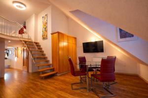 a dining room with a table and chairs and a staircase at Villa Viktoria 1 - Apartments - City center in Ingolstadt