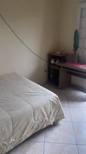 a bedroom with a bed next to a table at Condomínio azul in Paraty
