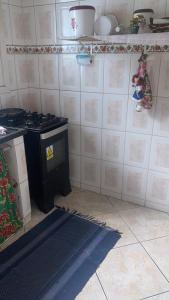 a kitchen with a stove and a rug on the floor at Condomínio azul in Paraty