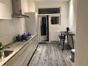 a kitchen with a sink and a table in it at Woonhuis 170m2 Rotterdam Centrum in Rotterdam