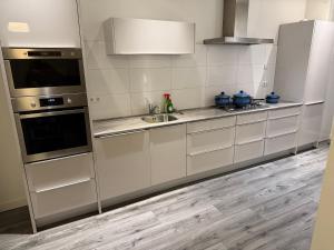a kitchen with white cabinets and a sink at Woonhuis 170m2 Rotterdam Centrum in Rotterdam