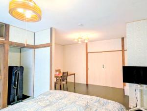 a bedroom with a bed and a desk and a table at Apt南熱海-網代 in Atami