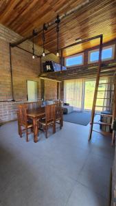 a large room with a wooden table and benches at CASA GRÊS - Pousada Vale das Escarpas in Timbe do Sul