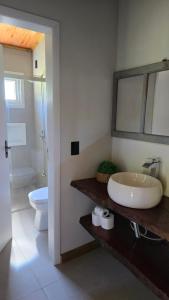 a bathroom with a sink and a toilet and a mirror at CASA GRÊS - Pousada Vale das Escarpas in Timbe do Sul