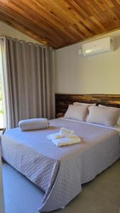 a bedroom with a large bed with towels on it at CASA GRÊS - Pousada Vale das Escarpas in Timbe do Sul