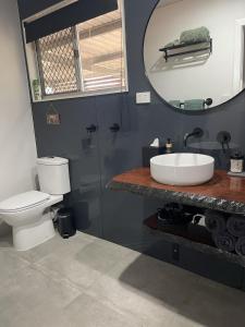 a bathroom with a toilet and a sink and a mirror at Hayden's Place in Wamuran +19 photos