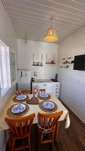 a kitchen with a table with two chairs and a tableablish at A Casinha de Madeira in Balneário Gaivotas