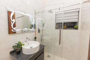 a bathroom with a sink and a shower and a mirror at Teflon suites Kumasi in Kumasi +55 photos