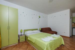a bedroom with a green bed with towels on it at Apartments Nada in Petrovac na Moru +45 photos
