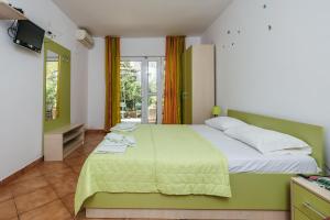 a bedroom with a bed with a green bedspread at Apartments Nada in Petrovac na Moru