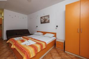 a small bedroom with a bed and a cabinet at Apartments Nada in Petrovac na Moru