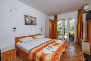 a bedroom with a bed with towels on it at Apartments Nada in Petrovac na Moru