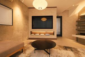 a living room with a table and a fire place at Crane Stay Shibuya in Tokyo