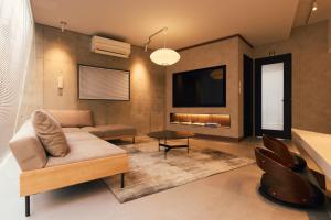 a living room with a couch and a tv at Crane Stay Shibuya in Tokyo