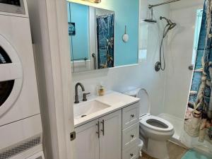 a white bathroom with a sink and a toilet at Seashell 5 in Boynton Beach +2 photos
