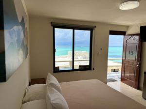 a bedroom with a bed and a view of the ocean at Charly Beach Hotel in Isla Mujeres