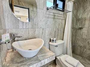 a bathroom with a sink and a toilet and a mirror at Charly Beach Hotel in Isla Mujeres +17 photos