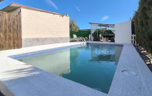 a swimming pool with blue water in a backyard at Cozy Home In Guillena in Guillena
