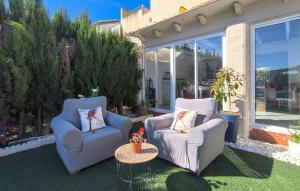 two chairs and a table on a lawn with a patio at Cozy Home In Guillena in Guillena +25 photos