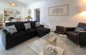 a living room with a black couch and a table at Cozy Home In Guillena in Guillena